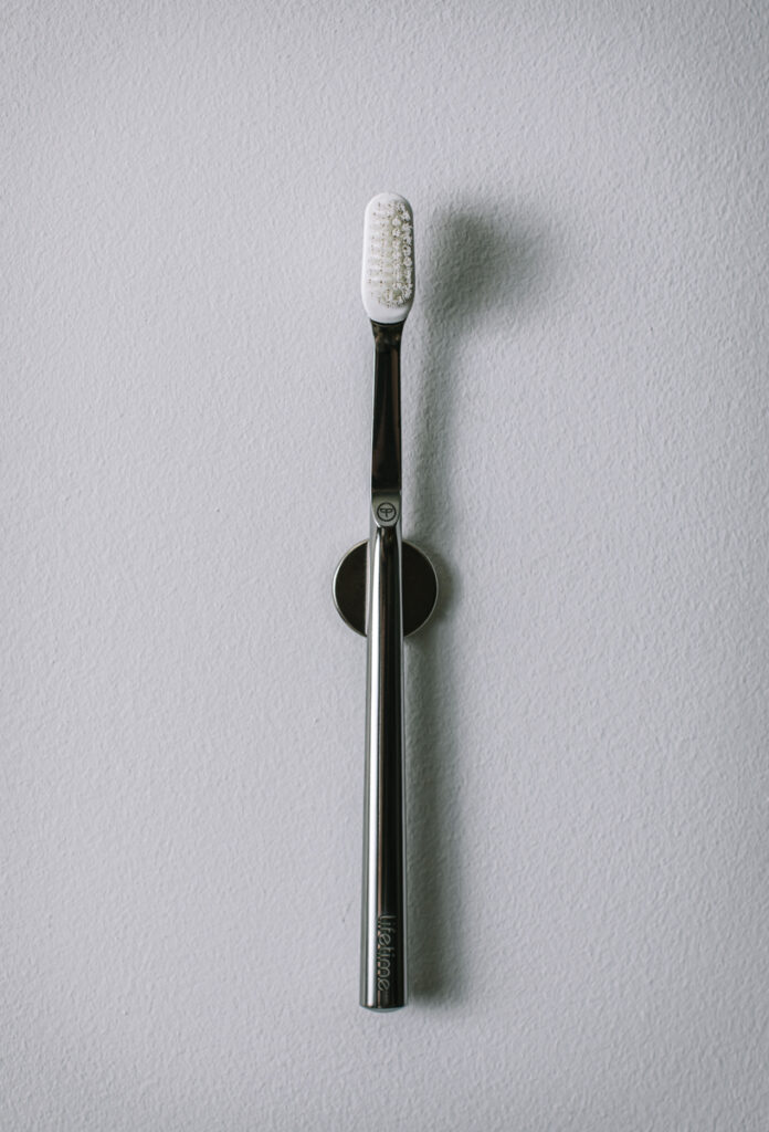 www.asimplelifetime.com Finding a Sustainable Toothbrush, Harder Than You Might Think. The Lifetime toothbrush attached to wall magnet stand.